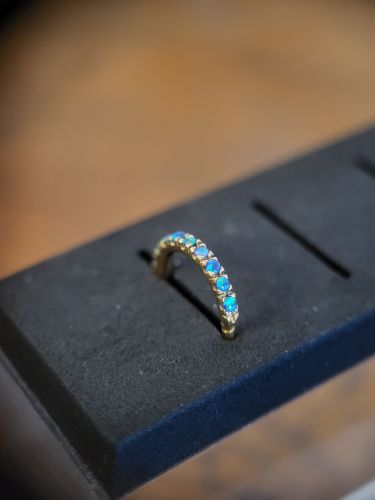 Runder Clicker in der Stärke 1.2 mm. Er ist mit Opal Steinen besetzt. Optimal für Ohrpiercings oder Septum. GOLD PVD SS316L JEWELLED CLICKER WITH OPAL (PRONG SETTING) - Lab Created Opal - Surgical Steel 316L - handpoliert